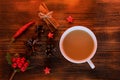 Coffee, spices and pine cones on a wooden background. Christmas concept. A cup of hot coffee with milk, cinnamon and chili on a wo Royalty Free Stock Photo