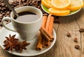 Coffee still life: a cup of coffee, coffee beans with cinnamon, anise and lemon Royalty Free Stock Photo