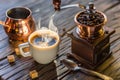 Coffee still-life. Hot cup of coffee and old-fashioned coffee grinder and cezve Royalty Free Stock Photo