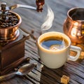 Coffee still-life. Hot cup of coffee and old-fashioned coffee grinder and cezve Royalty Free Stock Photo