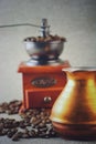 Coffee still life with wooden vintage grinder, Cezve, cup and coffee beans Royalty Free Stock Photo