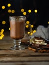 Coffee table. Glass cup coffee latte, chocolate, sweets, decor. Golden lights in the background. Wooden structure. Christmas, New