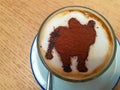 Coffee on the table have a dog graphic in the cup.