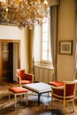 Bellagio, Italy - 07 june 2020: A coffee table with two armchairs and stools in a room with a window and curtains under