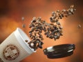 Coffee take away paper cup with coffee beans on a brown background