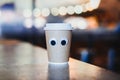 Coffee takeaway cup with cartoon eyes in cafe. Concept of hospitable cafe Royalty Free Stock Photo