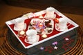 Coffee or tea party setup with decor, candles and chocolates and sweets on a tray with cups and saucers