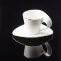 Coffee tea porcelain clay cup with saucer on the black mirror background. Copy space
