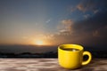 Coffee or tea in yellow cup on the wooden table opposite beautiful sunset over Mediterranean sea for background. Turkey in autumn Royalty Free Stock Photo
