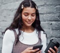 Coffee and technology go hand in hand. an attractive teenage girl standing alone and using her cellphone while holding a Royalty Free Stock Photo