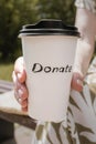 Paper cup with coffee and the inscription donate