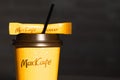 Coffee to go of McDonald`s with the inscription Maccafe in Russian stick with sugar on the table with a napkin and a straw. Fast Royalty Free Stock Photo