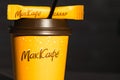 Coffee to go of McDonald`s with the inscription Maccafe in Russian stick with sugar on the table with a napkin and a straw. Fast Royalty Free Stock Photo