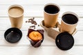 Coffee to-go, muffin on white wooden background. Translation of the Russian text on the lid is Caution: contents hot. Royalty Free Stock Photo