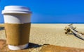 Coffee to go mug on the beach sand sea waves Royalty Free Stock Photo