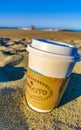 Coffee to go mug on the beach sand sea waves Royalty Free Stock Photo