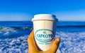 Coffee to go mug on the beach sand sea waves Royalty Free Stock Photo