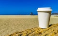 Coffee to go mug on the beach sand sea waves Royalty Free Stock Photo