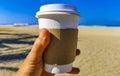 Coffee to go mug on the beach sand sea waves Royalty Free Stock Photo