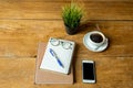 Coffee up and notebook, pen with glasses, cell phone on wooden table. Royalty Free Stock Photo