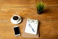 Coffee up and notebook, pen with glasses, cell phone on wooden table. Royalty Free Stock Photo