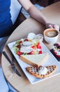 Coffee, waffle with ice cream, sandwich and salad with chicken and vegetables.