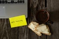 Coffee and white bread and butter on an old wooden table and the words in English good morning on yellow paper and a laptop Royalty Free Stock Photo