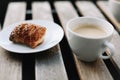 Coffee white cup, croissants on wooden table background. Breakfast concept. Freshly baked buns and coffee or cappuccino. Top view. Royalty Free Stock Photo