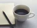 Coffee in white cup with Journal book and pencil Royalty Free Stock Photo