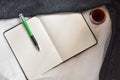 Coffee on a wine glass and an open blank notebook and a green pen. Royalty Free Stock Photo