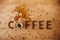 Coffee word made of  roasted coffee beans and spilled coffee from glass cup of hot espresso on wooden table, flat lay with copy Royalty Free Stock Photo