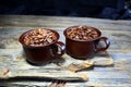 Coffeebeans in some ceramic coffee cups on a wooden table