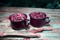 Coffeebeans in some ceramic coffee cups on a wooden table