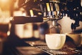 Coffeemaker pouring coffee into a cup.