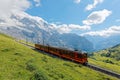 A cog wheel train traveling on famous Jungfrau Railway from Jungfraujoch station top of Europe Royalty Free Stock Photo