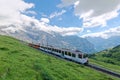 A cog wheel train traveling on famous Jungfrau Railway from Jungfraujoch station top of Europe Royalty Free Stock Photo