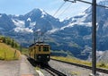 A cog wheel train traveling on the mountain Railway from Wengen to Kleine Scheidegg station Royalty Free Stock Photo