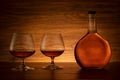 Cognac bottle with two glasses on wooden background Royalty Free Stock Photo