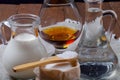 Cognac in a glass goblet, milk, water, sugar and salt in wooden