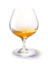 Cognac glass with gold cognac on a white