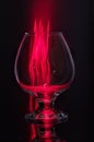 Cognac glass and red flame. Cognac glass on a black background Royalty Free Stock Photo