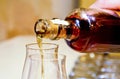 Cognac pouring from bottle into glass . Alcoholic, beverage Royalty Free Stock Photo