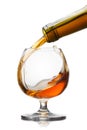 Cognac pouring into glass with splash on white backgrou Royalty Free Stock Photo