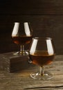 Cognac in two glasses on a dark wooden background. Toning. Royalty Free Stock Photo