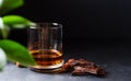 Cognac or whisky or brandy in a glass. Pieces of chocolate and hazelnuts. Dark background. Copy space Royalty Free Stock Photo
