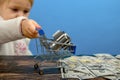 A cogwheel lies in a shopping cart and a child carries it on dollar bills. The concept of advertising cleanliness and decency in