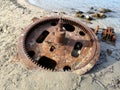 Cogwheel of old ship stranded on beach