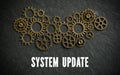Cogwheels and the words `system update` on slate background