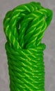 Coil green nylon rope on off-white background.