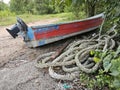 a coil of old nylon rope laying beside the wooden boat. Royalty Free Stock Photo